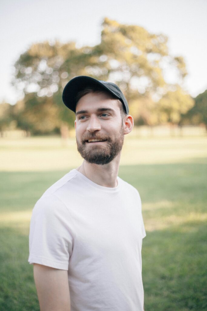 Man wearing a white tee and baseball cap.