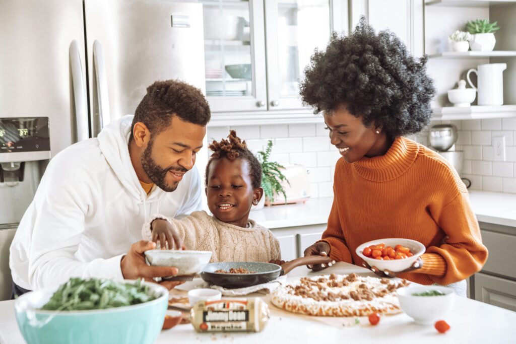 Mum, dad and son enjoying each others company in their family kitchen.