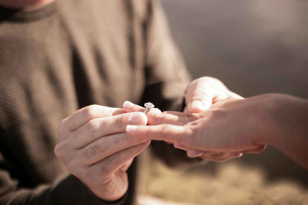 Man proposing to woman with a white gold engagement ring.