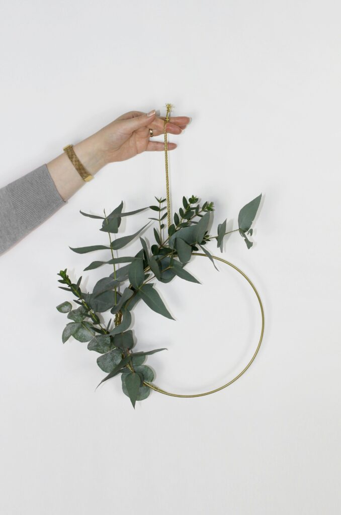 Lady holding up a eucalyptus wreath.