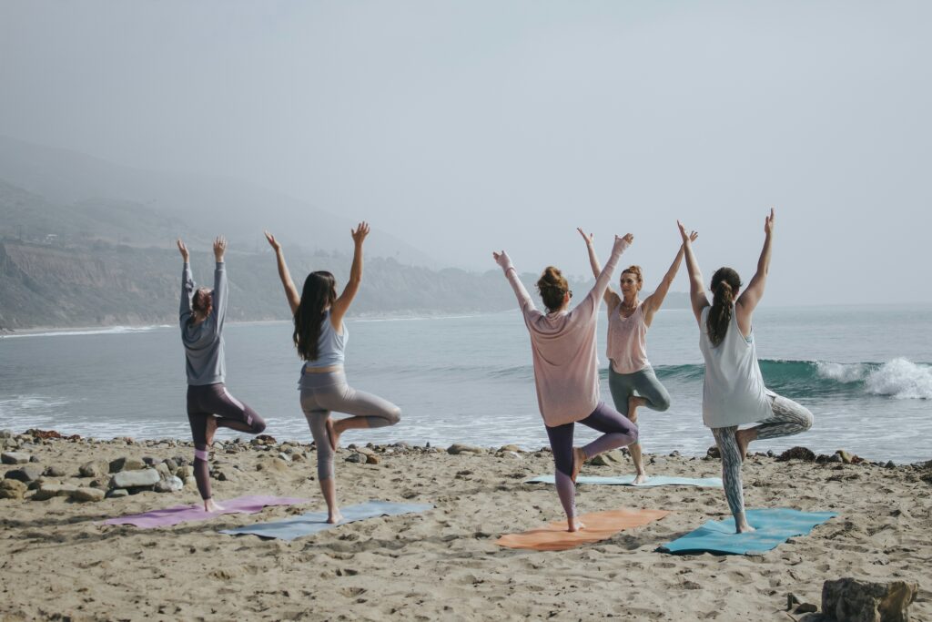 Yoga professional taking a class on a beach.