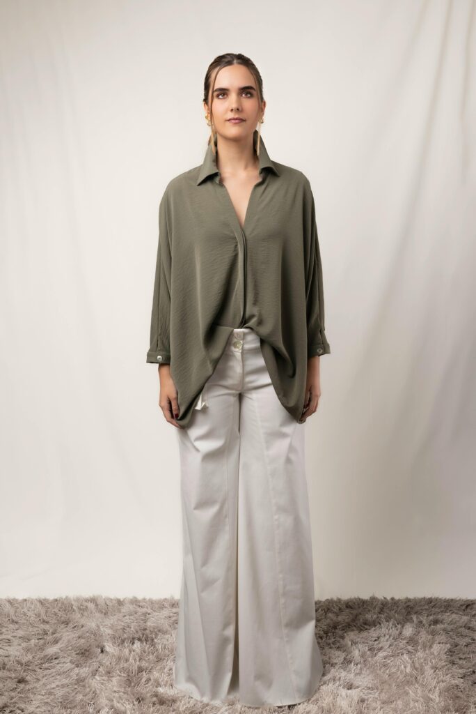 Woman wearing oversized shirt and wide leg tailored trousers.