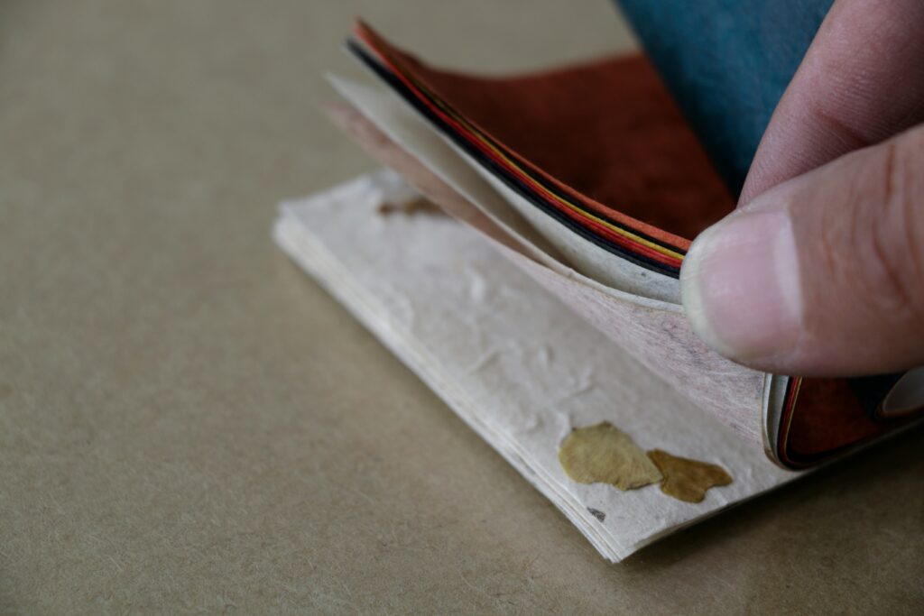 Person flicking a pad of seed paper.