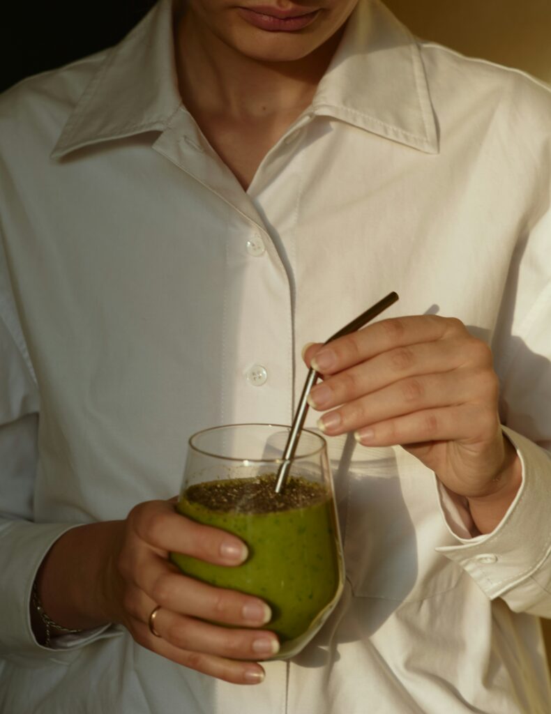 Wellness trends. Woman drinking green juice.