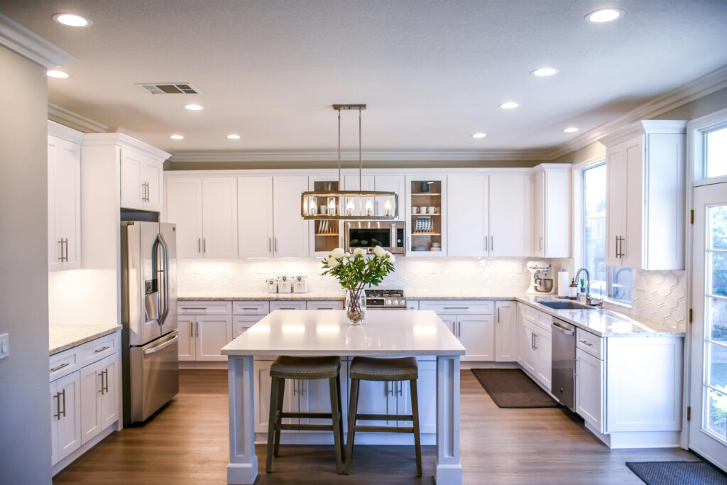 Neutral shaker style kitchen with flower arrangements on the counter top.
