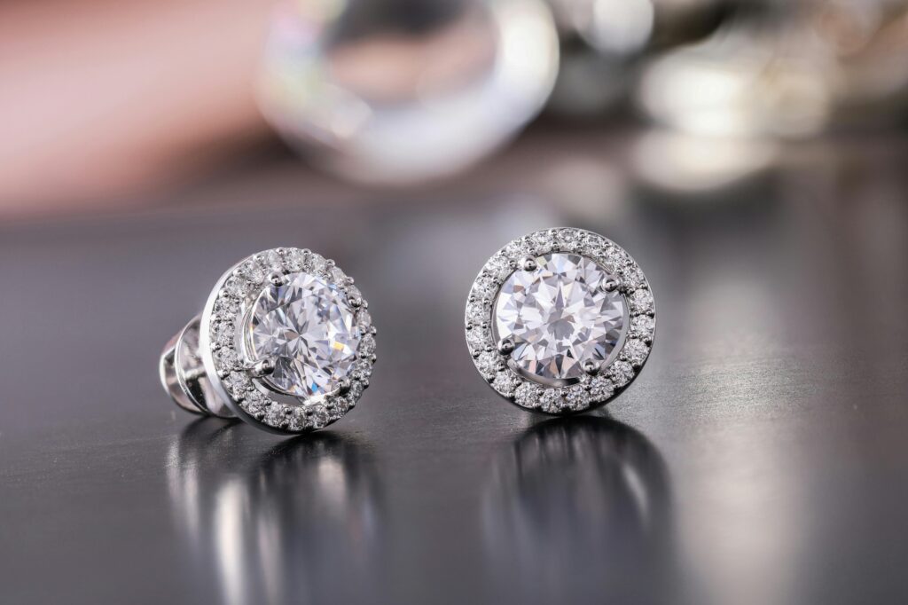 Luxury earrings. Diamond solitaire earrings with halo setting of diamonds around the outside.