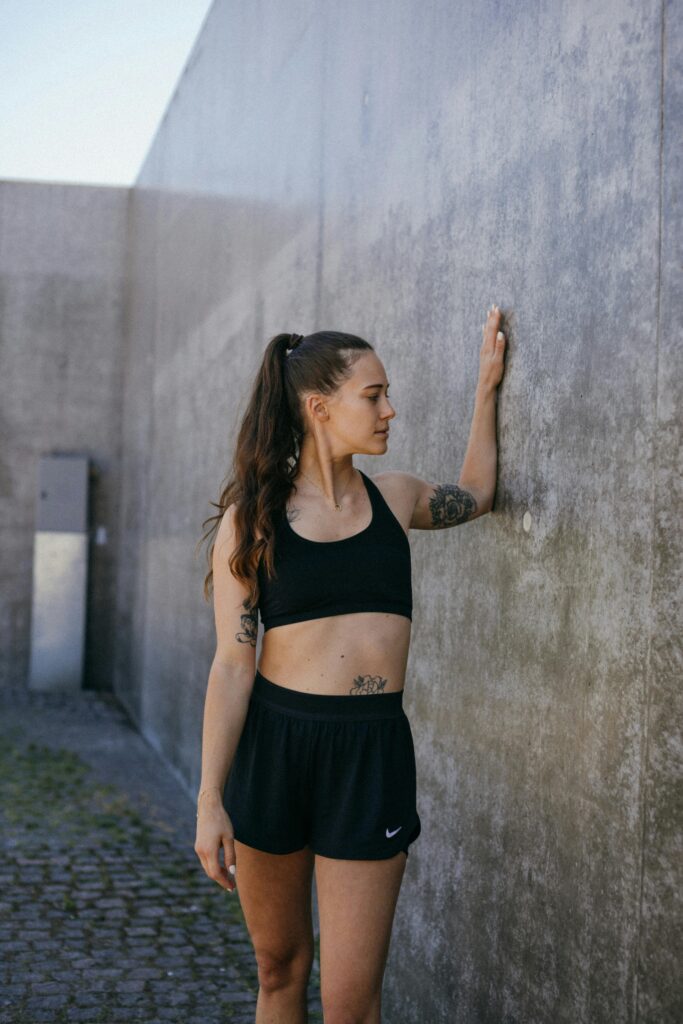 Woman wearing black workout crop top and shorts.