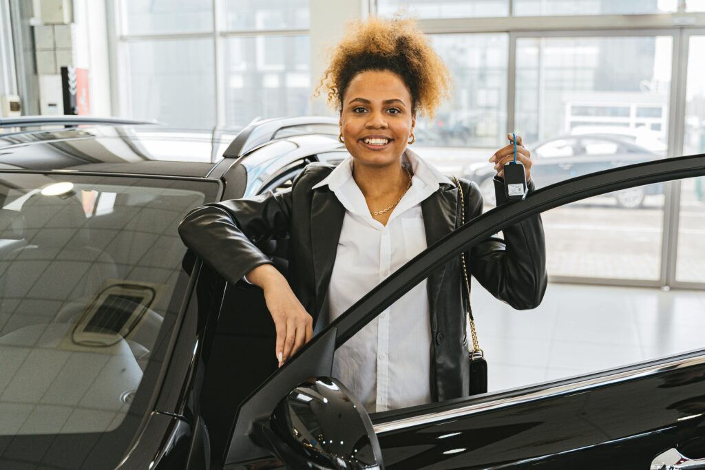 Lady smiling, holding car keys having taken out car finance.