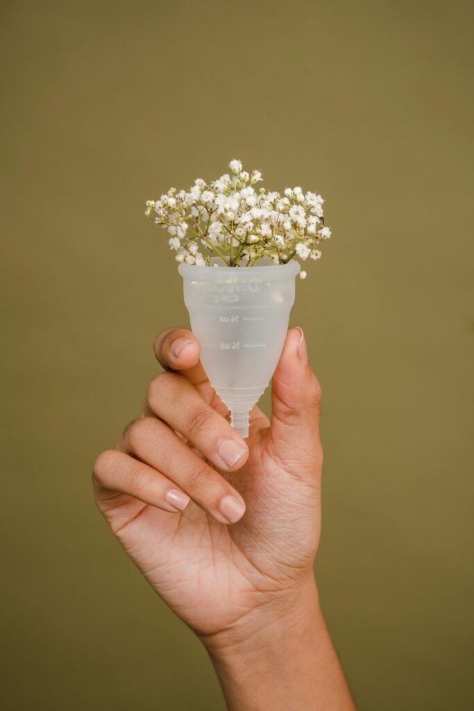 Hand holding up a menstrual cup. This is to go with an article discussing period delay options.