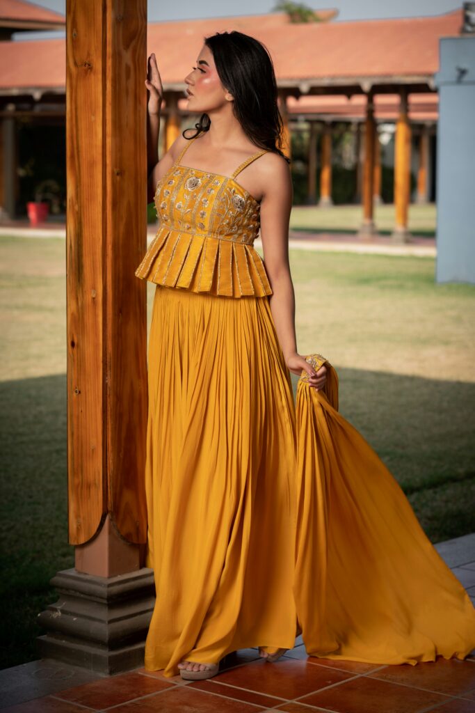 Woman wearing a yellow dress with embroidery detail on the top.