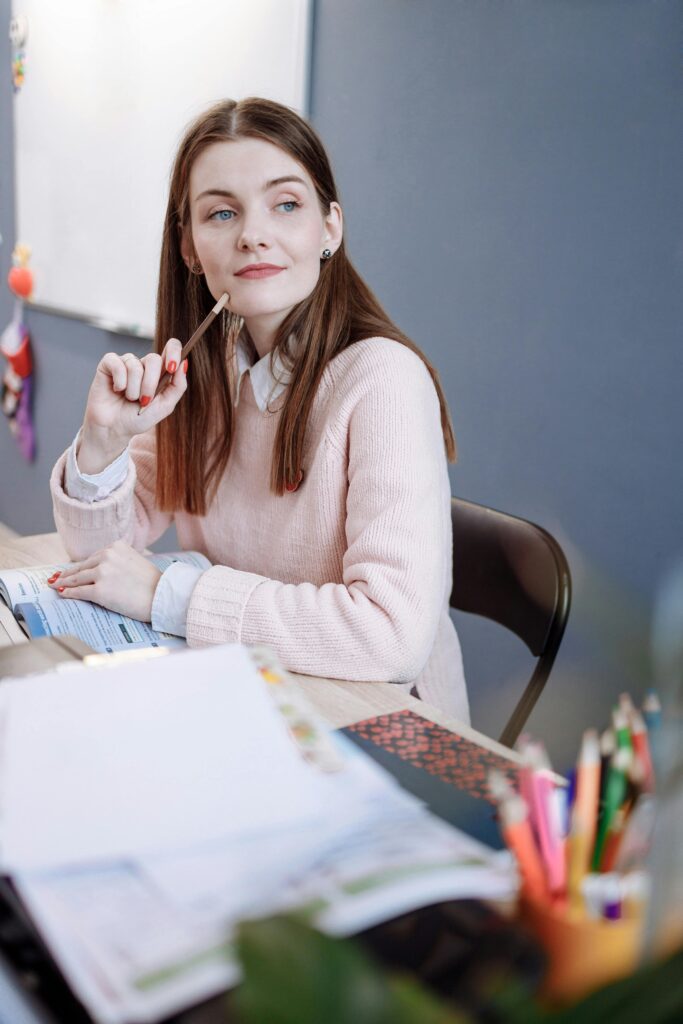 Woman sat at a desk wearing an outfit appropriate for teacher training.