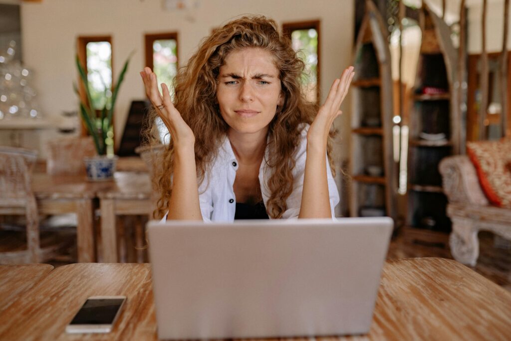 Woman looking confused ay online advertising on a laptop.