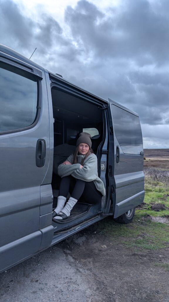 Claire Mac sat in the doorway of a campervan in North Yorkshire.