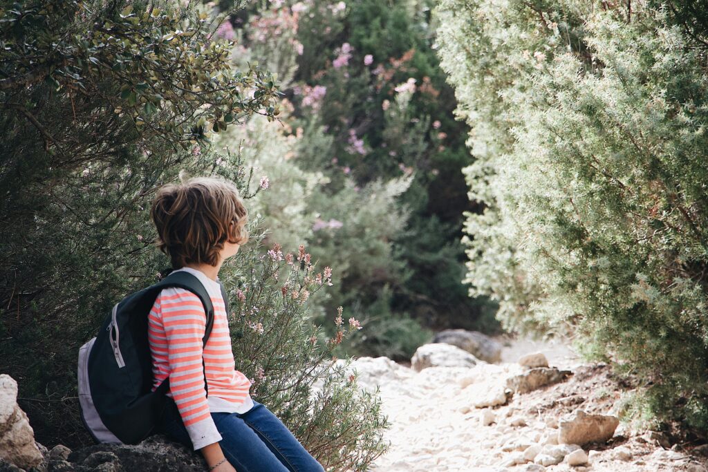 Boy out hiking wearing a rucksack.