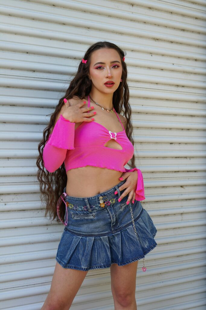 Girl with long wavy hear wearing Y2K fashion.