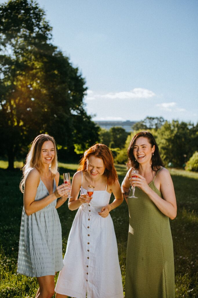 Three women enjoying drinks at a Wimbledon garden party.