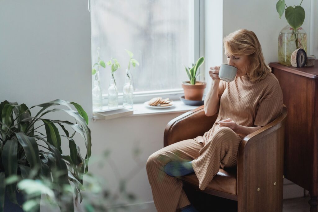 Lady sat i a chair at her relaxing retreat style home.