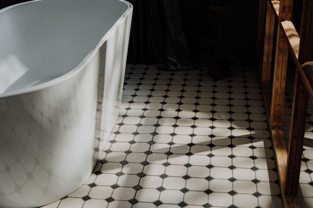 Landscape image, closeup of a bath on black and white tiles floor.