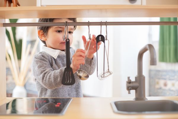 A young child having fun exploring kitchen utensils in a cozy indoor setting.