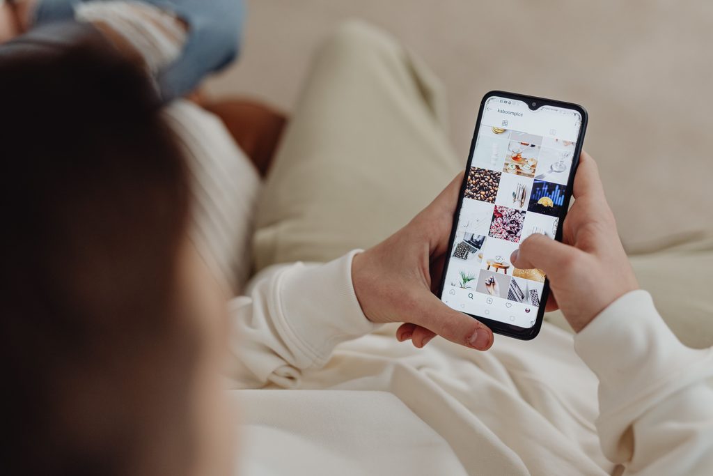 Person holding their phone out looking at Instagram. This is to go with an article giving tips on instagram growth.